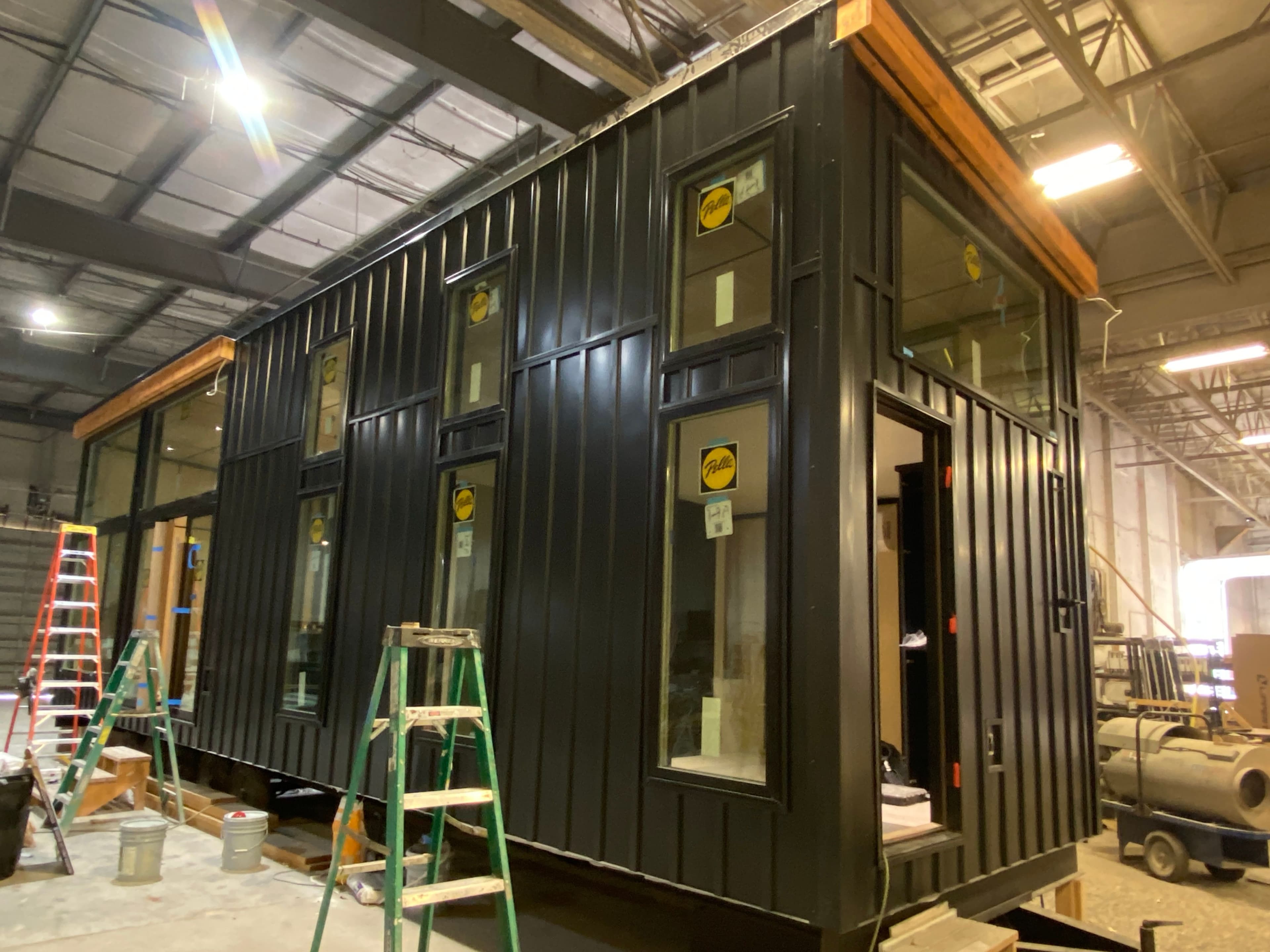 Montera Homes factory — completed modular home with dark steel exterior staged for delivery