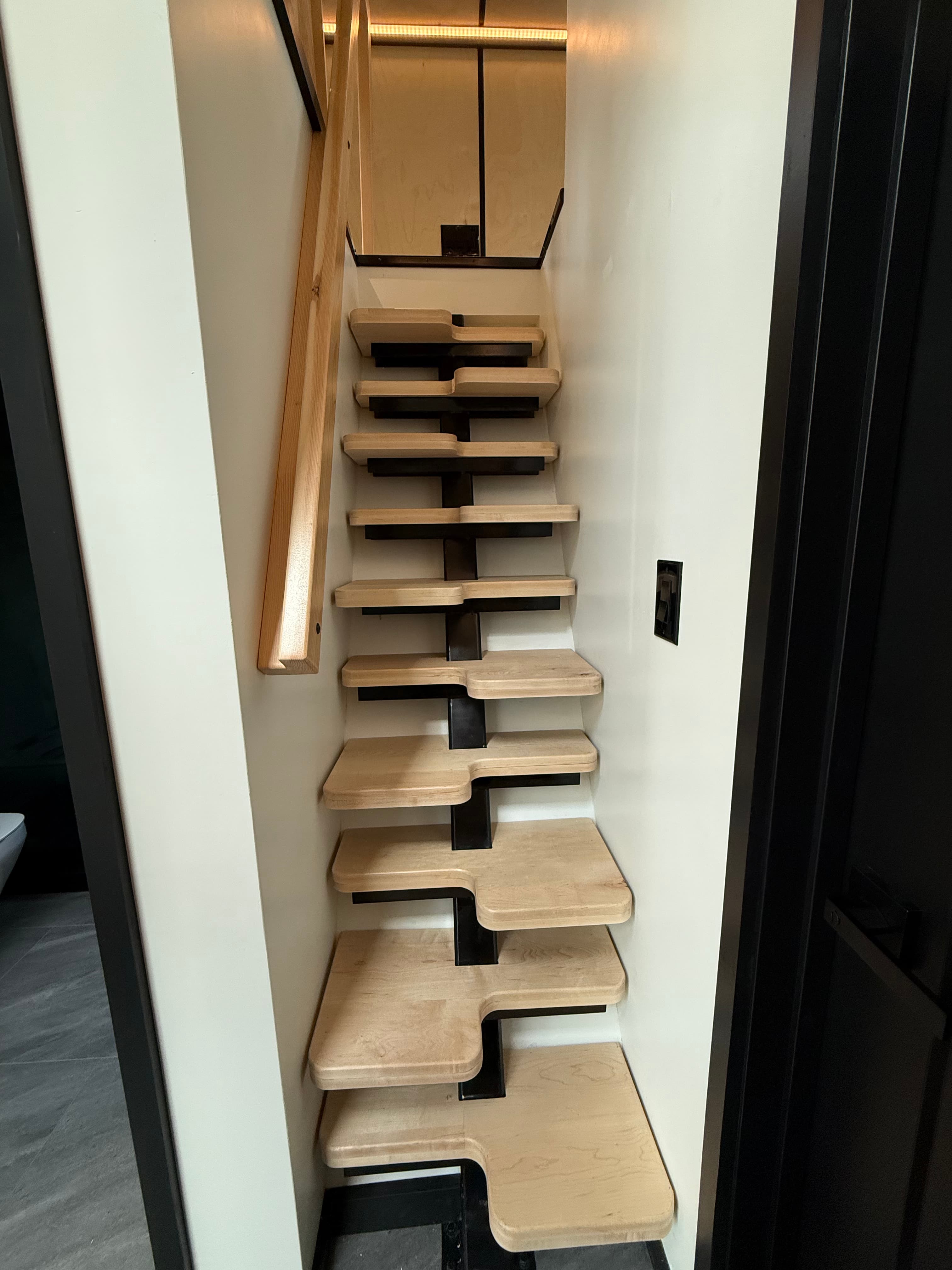 Montera Homes interior — custom pine and steel staircase leading to loft
