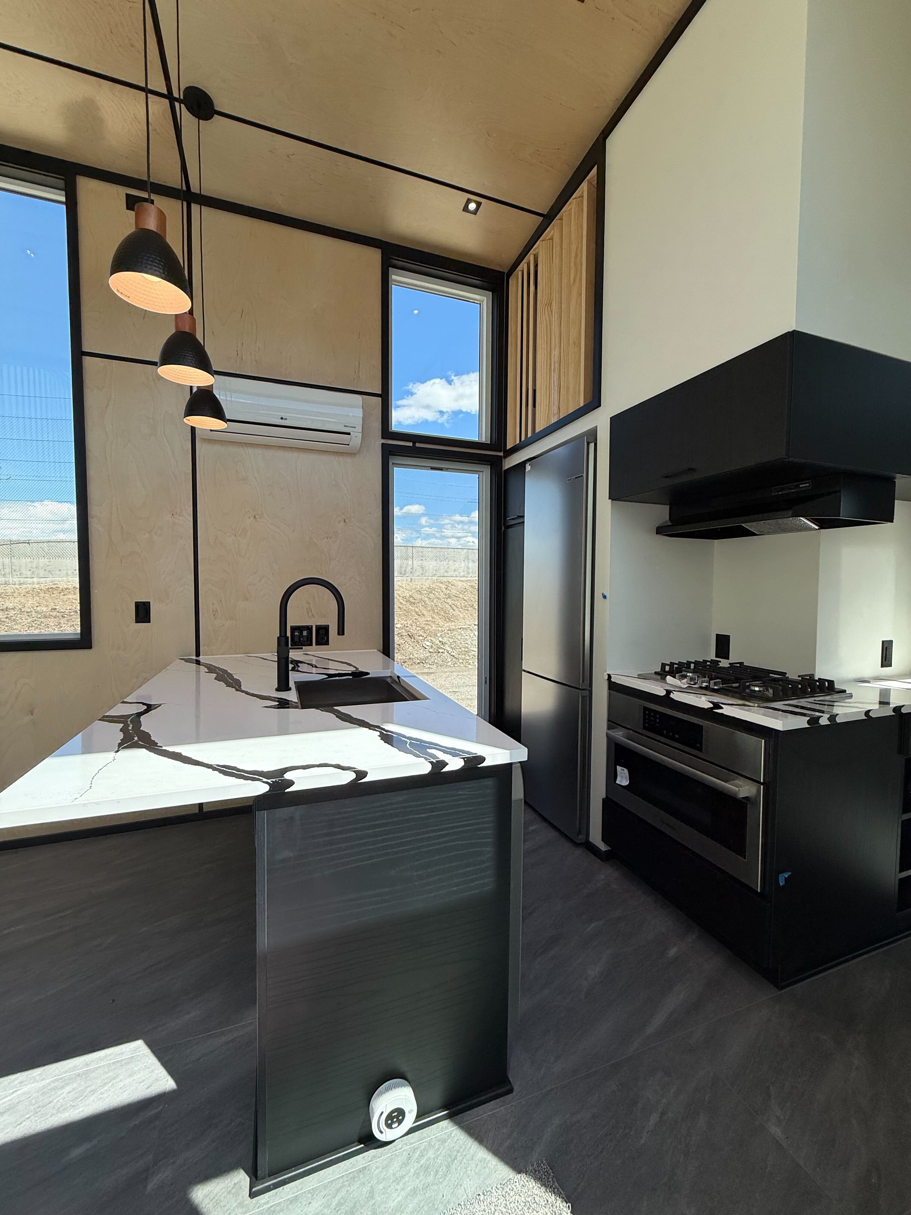 Montera Homes luxury interior — dark kitchen with pendant lighting and black cabinetry